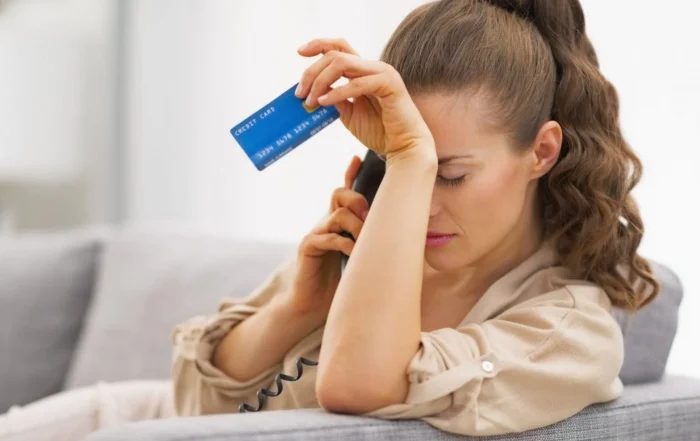 Mujer preocupada revisando estados de cuenta por dejar de pagar su tarjeta de crédito en México