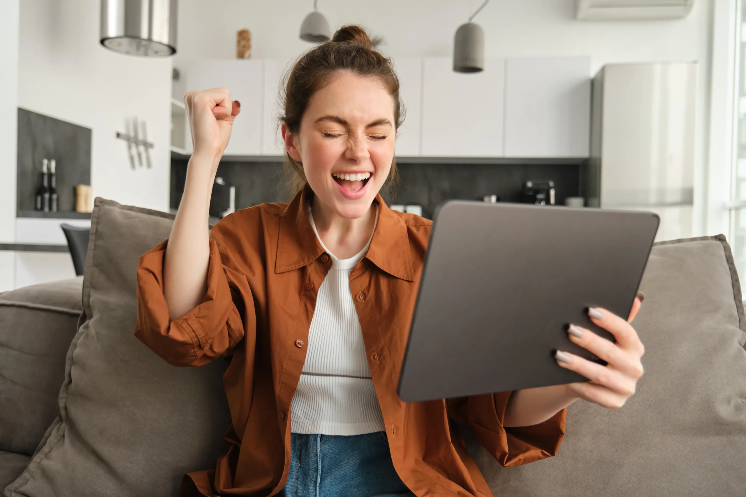 Mujer celebrando leyendo su dispositivo.